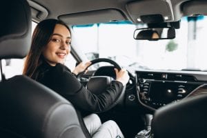 Button image of a young woman in a car for car insurance survey